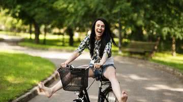 mulher andando de bicicleta feliz - Shutterstock