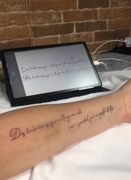 Imagem de um tablet e um braço tatuado