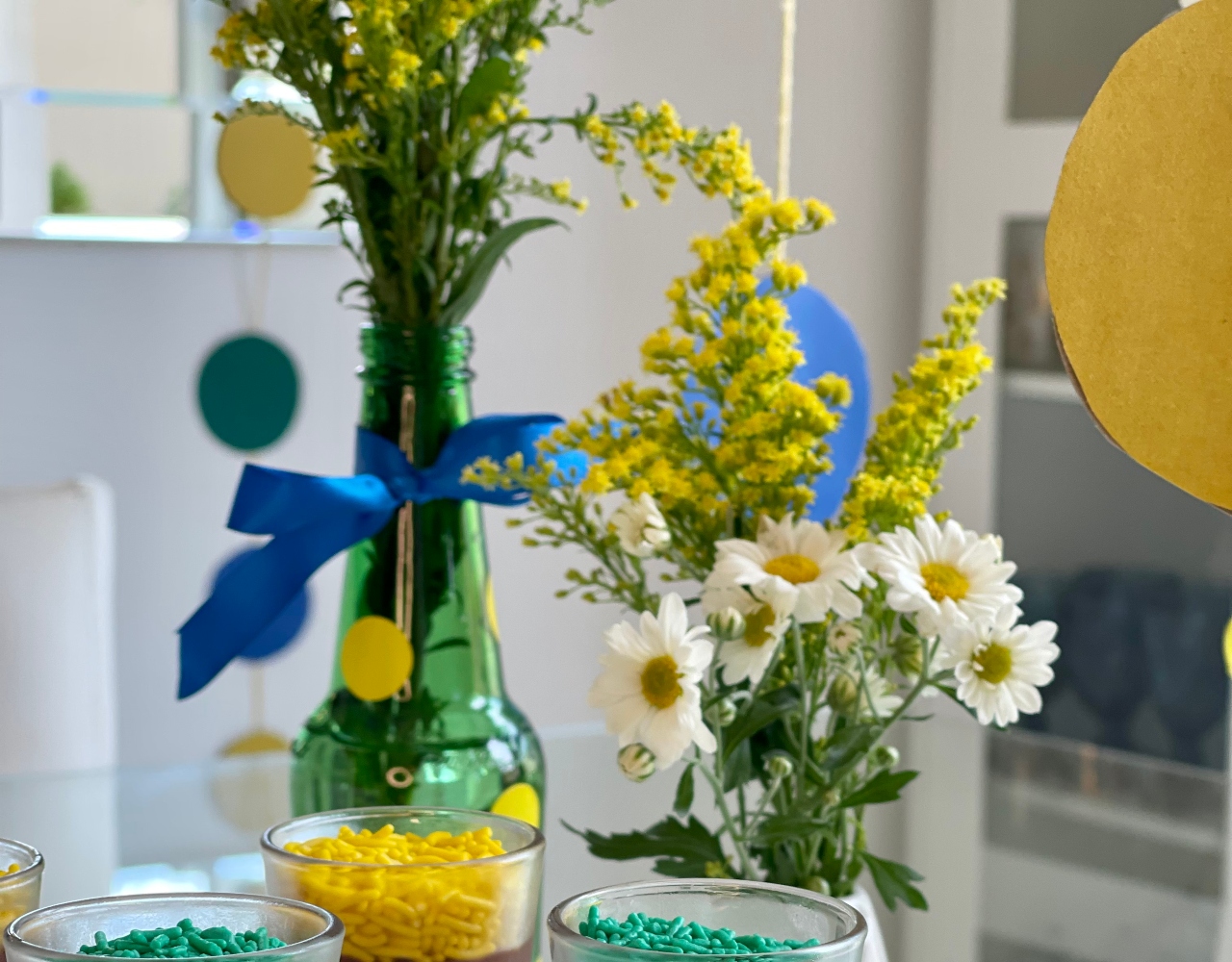 Vasos e garrafas verdes decoradas com flores